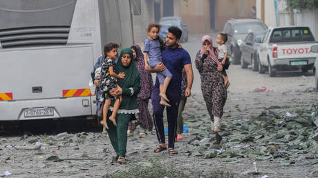 FILE PHOTO: Palestinians evacuate homes damaged by Israeli airstrikes in Gaza City, October 10, 2023.