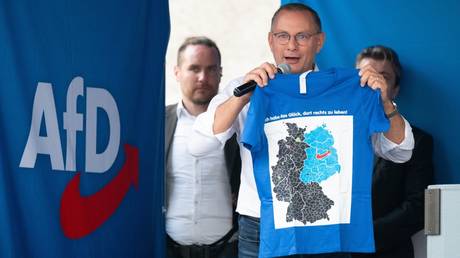 FILE PHOTO: AfD party's co-leader, Tino Chrupalla, holds a T-shirt with the inscription "I am lucky to live on the right" at an election rally in Saxony.