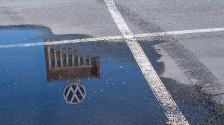 FILE PHOTO: The Volkswagen brand tower is reflected in a puddle on an employee parking lot in front of the VW plant in Wolfsburg, Germany.