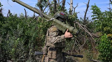 FILE PHOTO: A Russian serviceman carries a portable anti-aircraft missile system at a combat position in Russia's Donetsk People's Republic.