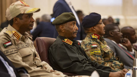 Head of Sudanese ruling Sovereign Council and Commander-In-Chief of the Sudanese Armed Forces Abdel Fattah al-Burhan (C) and his Deputy Mohamed Hamdan Dagalo (L).