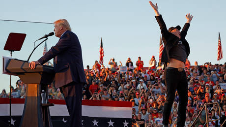 Elon Musk leaps on stage with Republican presidential nominee, former President Donald Trump, during a campaign rally at the Butler Farm Show fairgrounds on October 05, 2024 in Butler, Pennsylvania.