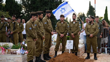 Israeli soldiers stand guard around the grave of a comrade killed in Lebanon, during his funeral near Tel Aviv, Israel, October 6, 2024