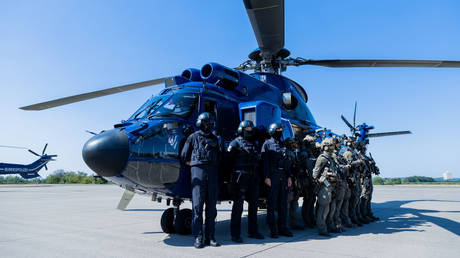 FILE PHOTO: Task forces of the GSG 9 and the Federal Police Air Squadron stand in front of a helicopter in Sankt Augustin, Germany, on August 8, 2022.