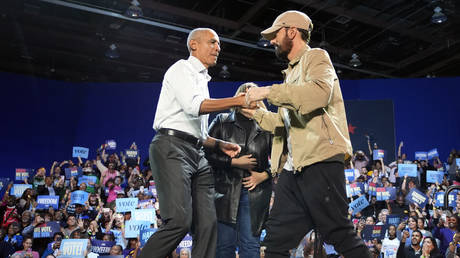 Rapper Eminem (R) and former US President Barack Obama (L) at a campaign rally for presidential candidate Kamala Harris, Detroit, Michigan, October 22, 2024.