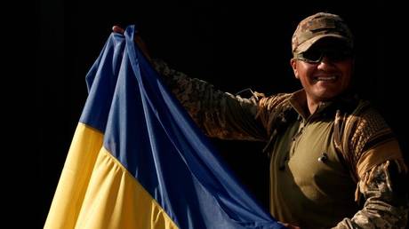 FILE PHOTO: A foreign mercenary holding a Ukrainian flag.