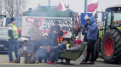 Polish protesters sit around a campfire in Kazun Polski near Warsaw, Poland, on Wednesday March 20, 2024.