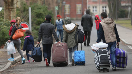 FILE PHOTO: People pulling suitcases arrive at the Central Registration Office for Asylum Seekers in Berlin, Germany.