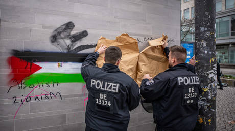 FILE PHOTO: Police officers cover an anti-Israel smearing with paper in front of a pro-Palestinian demonstration at Hermannplatz in Neukölln, Berlin, Germany, on December 30, 2023.