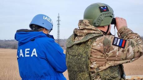 A Russian serviceman and an IAEA inspector at the line of contact near the Karachekrak River in Russia's Zaporozhye Region.