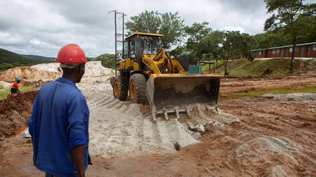 FILE PHOTO: A foreman looks on as a bulldozer works on the slippery road at Arcadia Lithium mine on January 11, 2022 in Goromonzi, Zimbabwe.