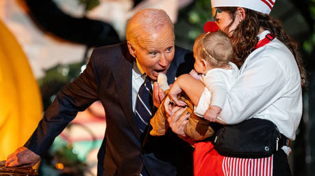 US President Joe Biden playfully greets a baby as he and first lady Jill Biden greet trick-or-treaters during a Halloween event at the White House on October 30, 2024 in Washington, DC.