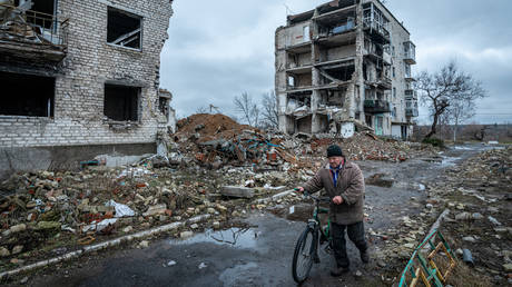 File photo: A Ukrainian civilian walks through a devastated residential neighborhood in Izyum.