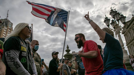 FILE PHOTO. Pro-Trump (R) and anti-Trump demonstrators argue at the Michigan state capitol in Lansing, Michigan.