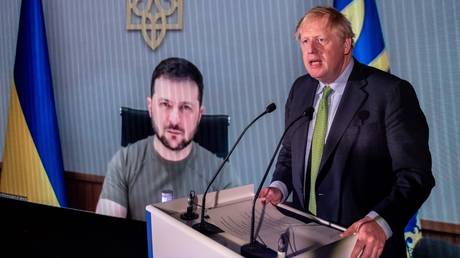 FILE PHOTO: Boris Johnson speaks in front of a live video feed showing Ukrainian leader Vladimir Zelensky