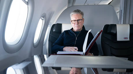 British Prime Minister Sir Keir Starmer works on board a Government plane.