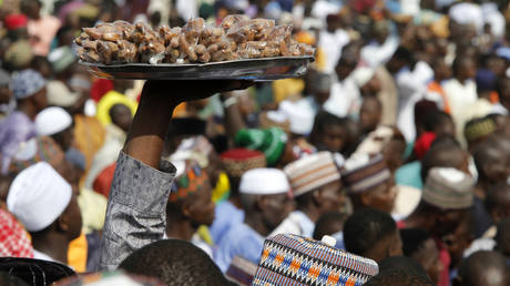 FILE PHOTO. A man selling dates while walking around during the Eid-el-Fitr celebration marking the end of Ramadan, Lagos, Nigeria.