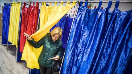 A woman exists a voting booth during the Romanian presidential election.