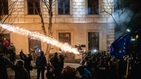 Protesters shoot fireworks at the riot police outside Parliament House in Tbilisi, Georgia