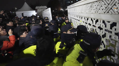 People try to enter as police officers stand guard in front of the National Assembly in Seoul, South Korea, Tuesday, Dec. 3, 2024.