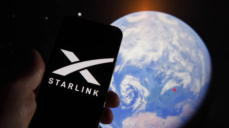 The Starlink logo is seen on a mobile device with an grahpic illustration of planet Earth in the background.