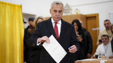 Calin Georgescu, an independent candidate for president who came first after the first round of presidential elections, casts his vote in the country's parliamentary elections, in Mogosoaia, Romania, Sunday, Dec. 1, 2024.