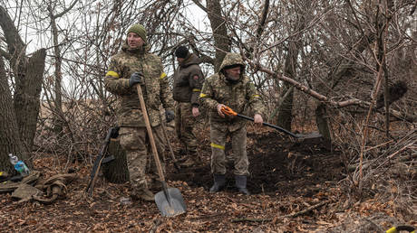 FILE PHOTO: Ukrainian soldiers dig a shelter to protect themselves from artillery.