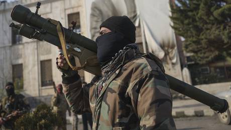 A Syrian opposition fighter in front of the provincial government office in the aftermath of the opposition’s takeover of Hama, Syria, December 6, 2024.