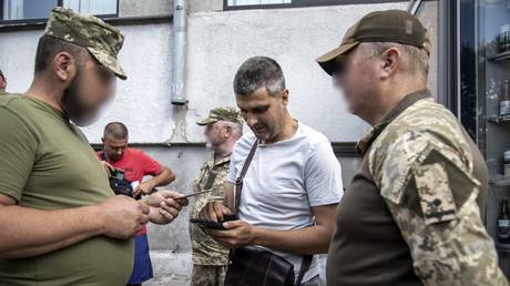 FILE PHOTO: Ukrainian draft scouts check a man’s ID in the city of Kharkov.