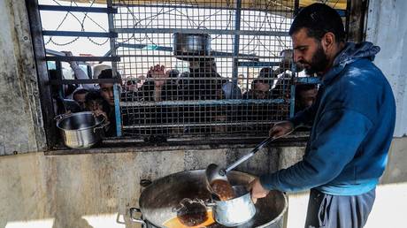 FILE PHOTO: Charitable organizations distribute food to displaced Palestinians in Khan Yunis, Gaza.