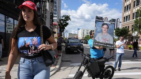 A Democrat protester holds a poster depicting would-be assassin Thomas Matthew Crooks as a hero, during the Republican National Convention in Milwaukee, July 17, 2024.