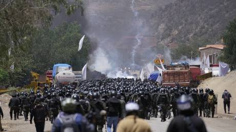 Police officers advance towards supporters of former President Evo Morales, who are blocking a road near Parotani, Bolivia on November 1, 2024.