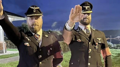 Two British Army soldiers perform Nazi salutes at a costume party in Wiltshire, England