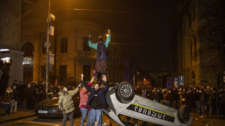 FILE PHOTO: Protestors damage the police car as they clash with Police that are using water cannons, pepper spray and tear gas against protesters on March 8, 2023 in Tbilisi, Georgia.