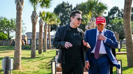 FILE PHOTO: US President-elect Donald Trump walks with his ally Elon Musk.