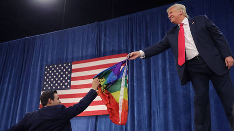 FILE PHOTO: Donald Trump returns an LGBT flag given to him by a supporter during a campaign rally on October 30, 2016