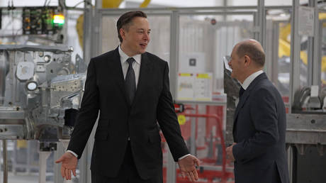 FILE PHOTO: Tesla CEO Elon Musk stands next to German Chancellor Olaf Scholz during the opening of a Tesla plant near Gruenheide on March 22, 2022