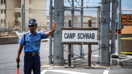 FILE PHOTO: A security guard mans the main entrance to Camp Schwab, a United States military base in Nago, Okinawa prefecture, Japan.