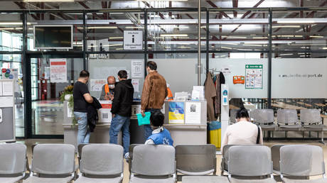 FILE PHOTO: Asylum seekers at the information desk at the temporary refugee  center at former Tegel airport in Berlin, Germany, May 19, 2023.