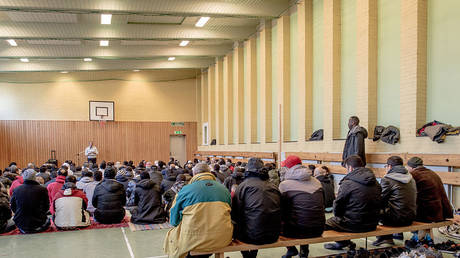 Refugees pray in the gym of the Sweden's largest temporary camp in Vanersborg, Sweden, February 12, 2016