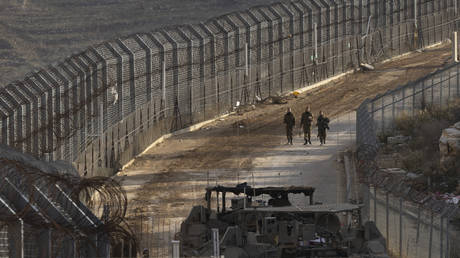 FILE PHOTO: Israeli soldiers walk a long the border with Syria as seen from the Israeli side of the border on December 9, 2024 in Golan Heights.