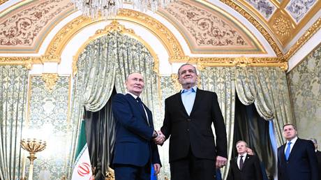 Russian President Vladimir Putin and Iranian President Masoud Pezeshkian shake hands as they pose for photos before a meeting at the Kremlin in Moscow, Russia.