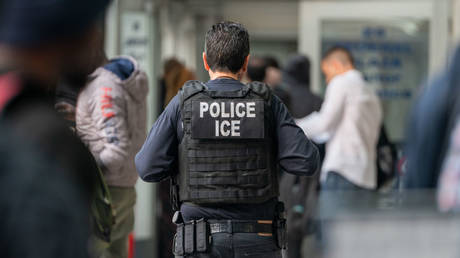 An ICE agent monitors hundreds of asylum seekers being processed in New York City, June 6, 2023