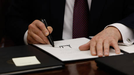 US President Donald Trump signs executive orders in the Oval Office on January 20, 2025.